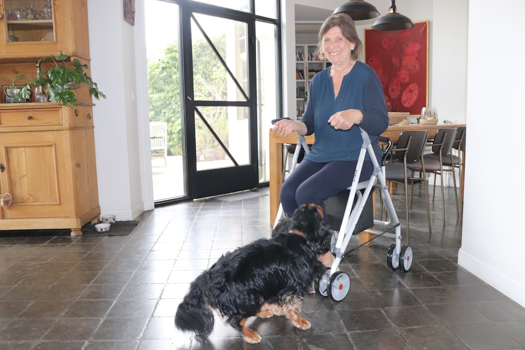 Woman sitting with walker is interacting with a dog.