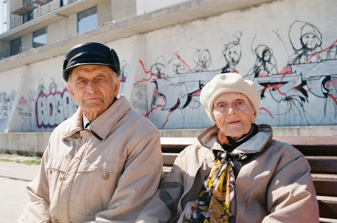 a man and woman standing in front of a wall with graffiti